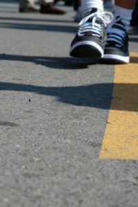 A person 's feet are shown on the street.