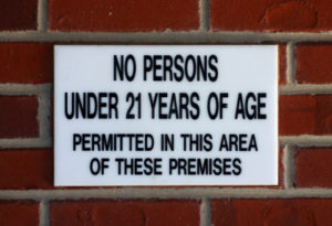 A sign on the side of a brick wall.