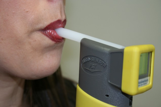 A woman is using an electronic cigarette to smoke.