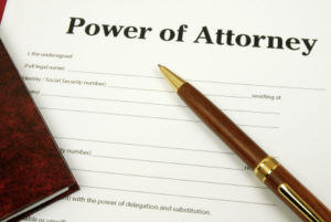 A pen and paper sitting on top of a power of attorney form.