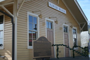 A building with a plaque and sign in front of it.