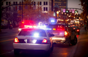 A police car is stopped at an intersection.