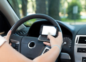 A person holding their cell phone while driving.