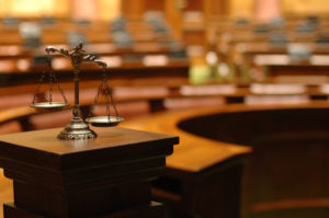 A wooden table with a statue of justice on top.