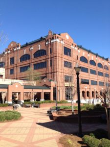 A large brick building with many windows and a walkway.