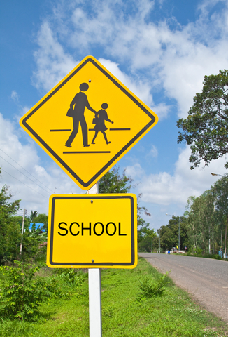 A yellow sign with a picture of a child and a parent.