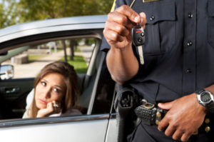 A police officer holding a car key and talking on the phone.