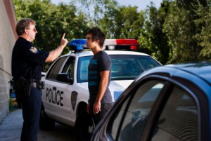 A police officer giving the finger to a man in front of a cop car.