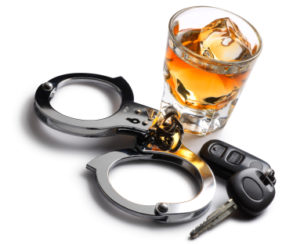 A glass of alcohol and handcuffs with keys.