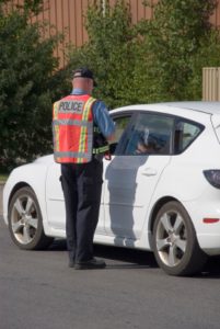 A police officer is standing in front of the car.