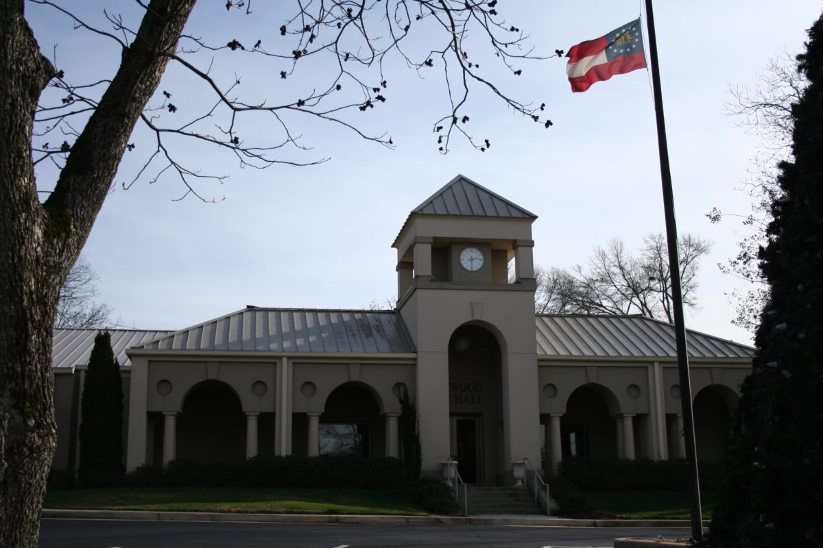 A building with a clock tower and a flag flying.