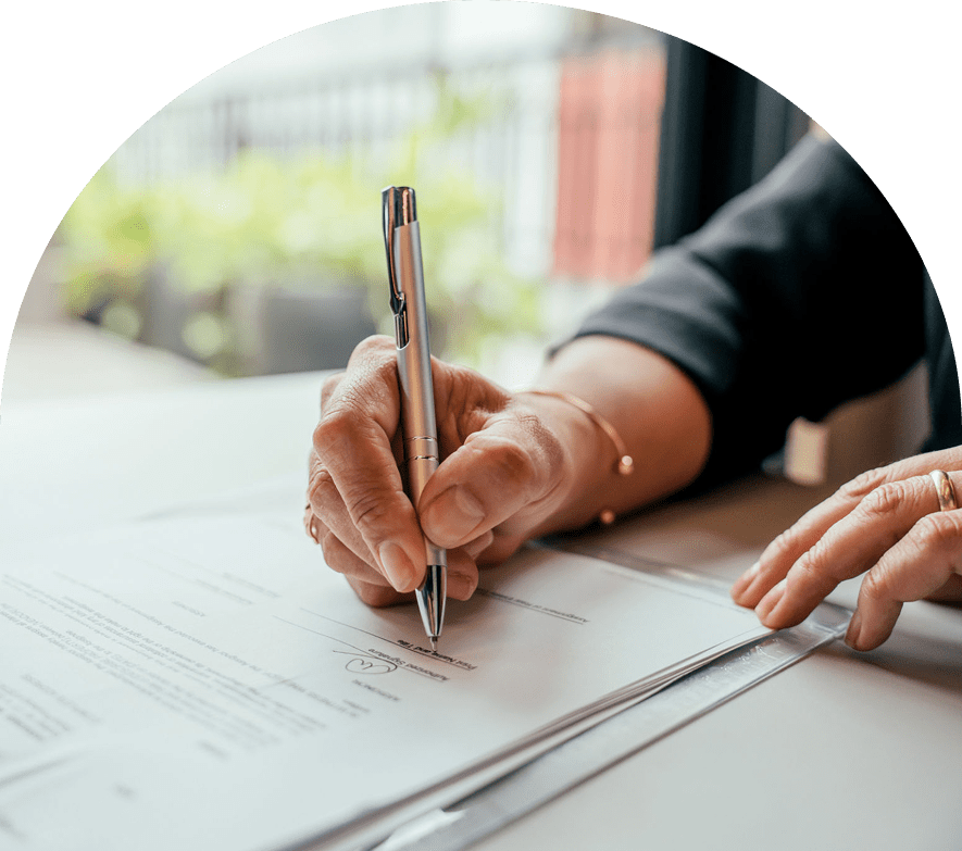 Signing a document with a pen.