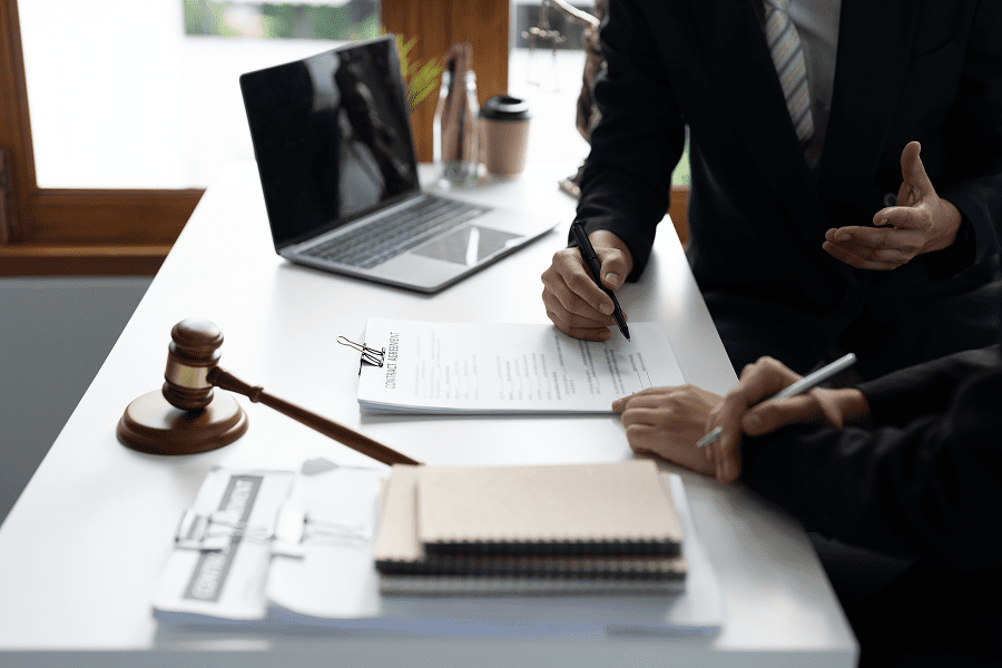 Lawyers discussing documents at office desk.