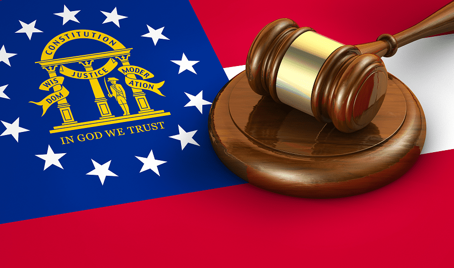 Georgia flag with gavel on wooden block.