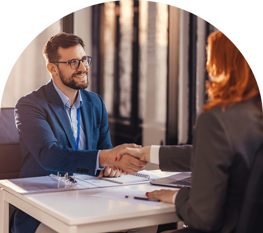 Two people shaking hands in office.